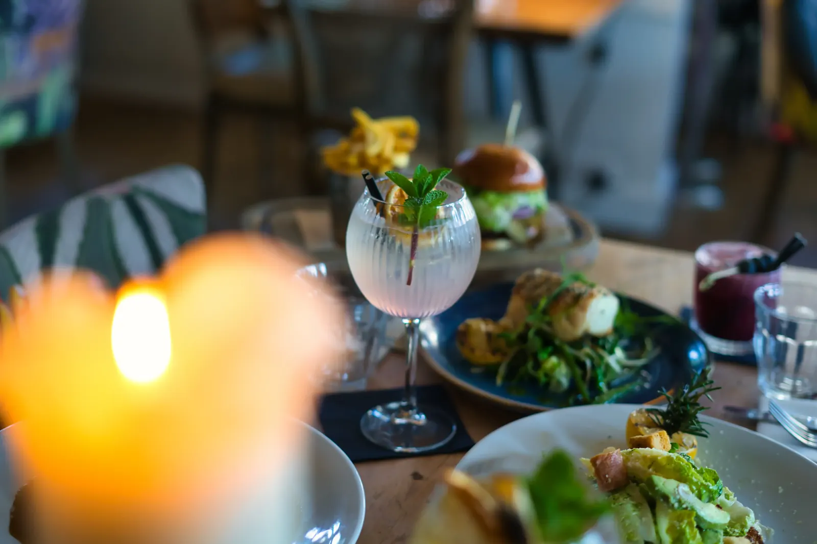 Refreshing cocktail in a stemmed glass with mint garnish on a dining table