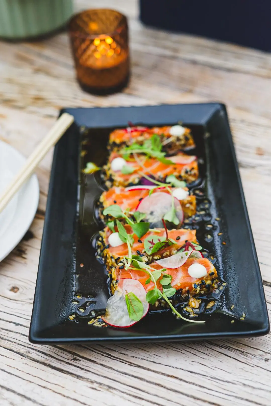 Sesame-crusted salmon sashimi with radish and microgreens