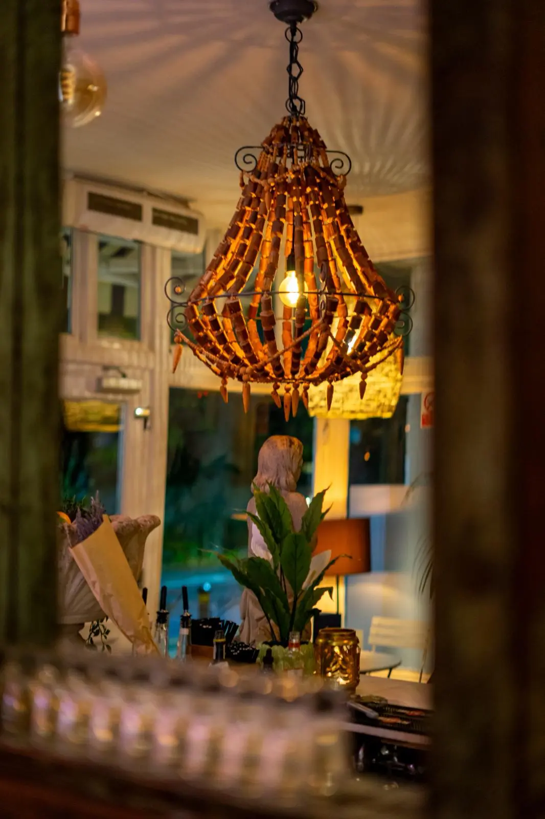 Beaded chandelier glowing above a cosy restaurant bar at night